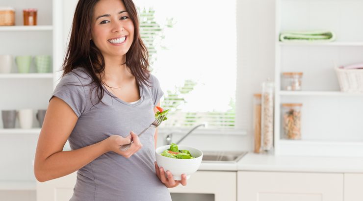 Gravid kvinna äter sallad