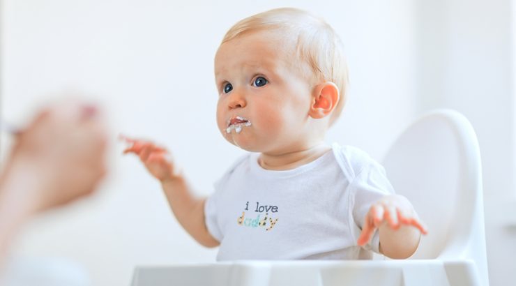 Baby som äter vid matbord