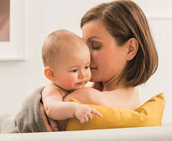 Mother lovingly holds her baby in her arms Mother lovingly holds her baby in her arms