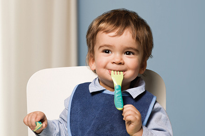 Baby boy with MAM Learn to Eat cutlery in Green