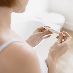 Woman holds a pregnancy testing kit in her hand and waits for the result Woman holds a pregnancy testing kit in her hand and waits for the result