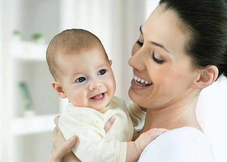 A baby aged about 3 months snuggles into its mother's shoulder A baby aged about 3 months snuggles into its mother's shoulder