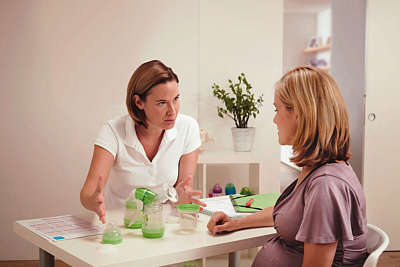 Pregnant woman is shown MAM products by a medical expert 