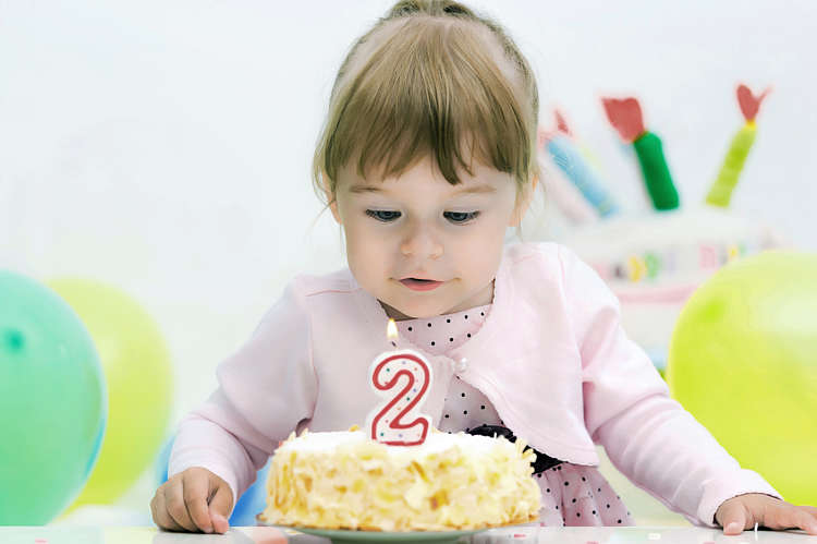 Baby girl celebrates her second birthday with a cake