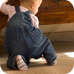 Baby pulls itself up on a cupboard Baby pulls itself up on a cupboard