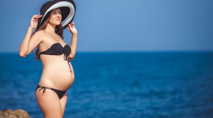 Gravid kvinna på stranden