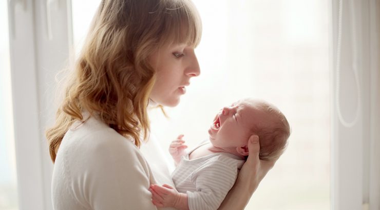 Mamma håller i skrikande baby