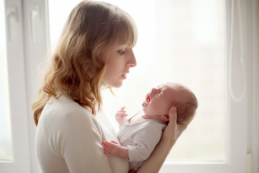 Mamma håller i skrikande baby